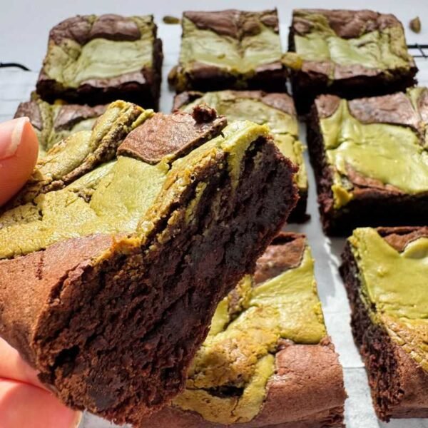 Hand holding a pistachio brownie slab piece